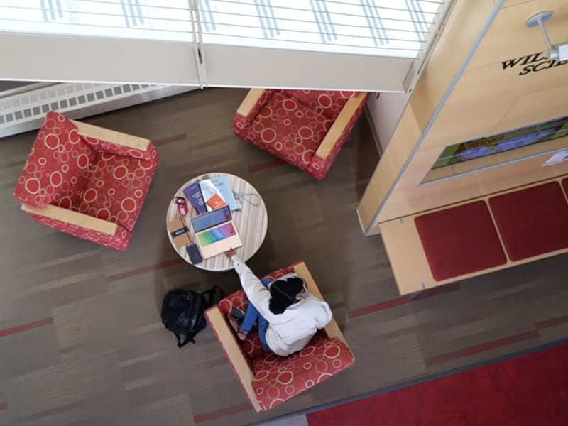 Overhead view of Roberts Weselyan University student doing coursework in lounge