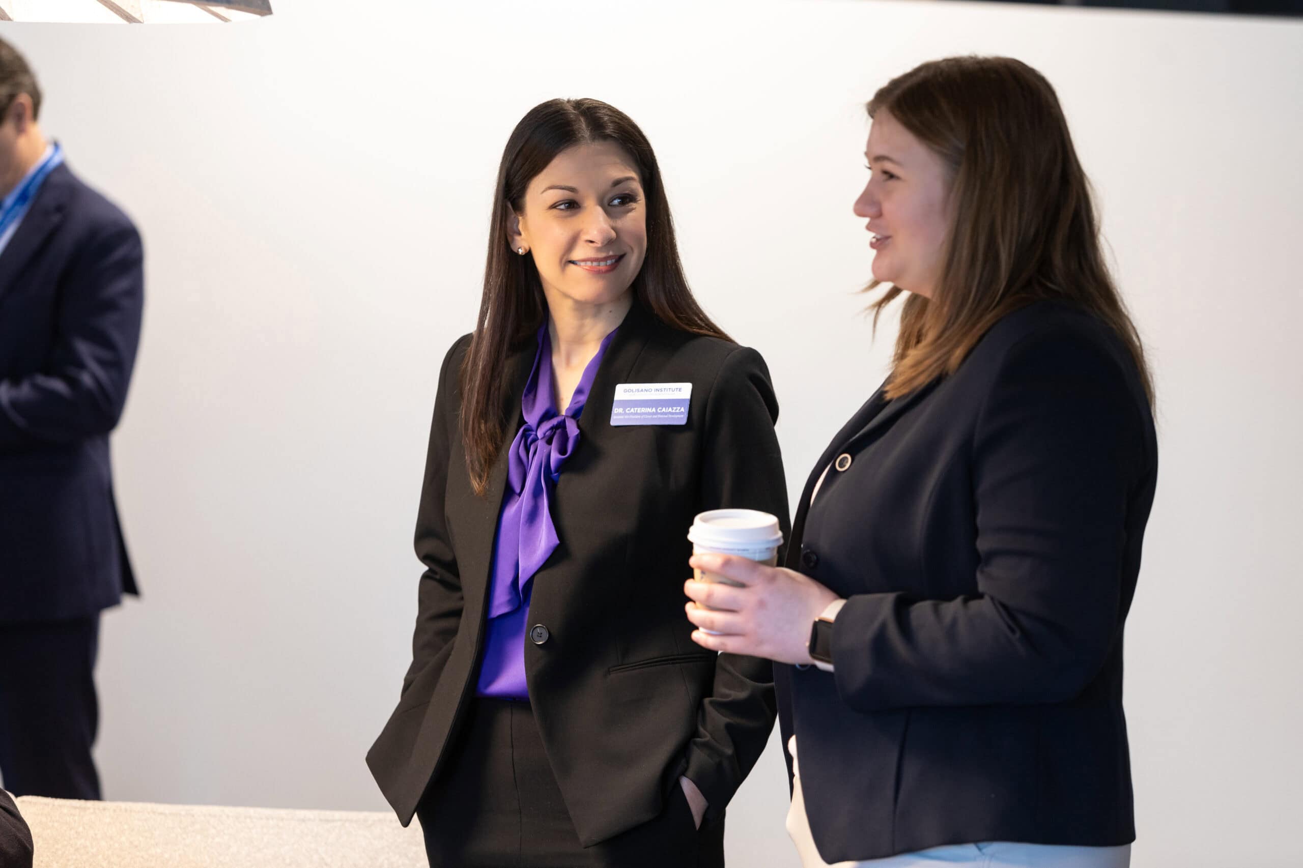 A teacher and student talk in an event setting. 