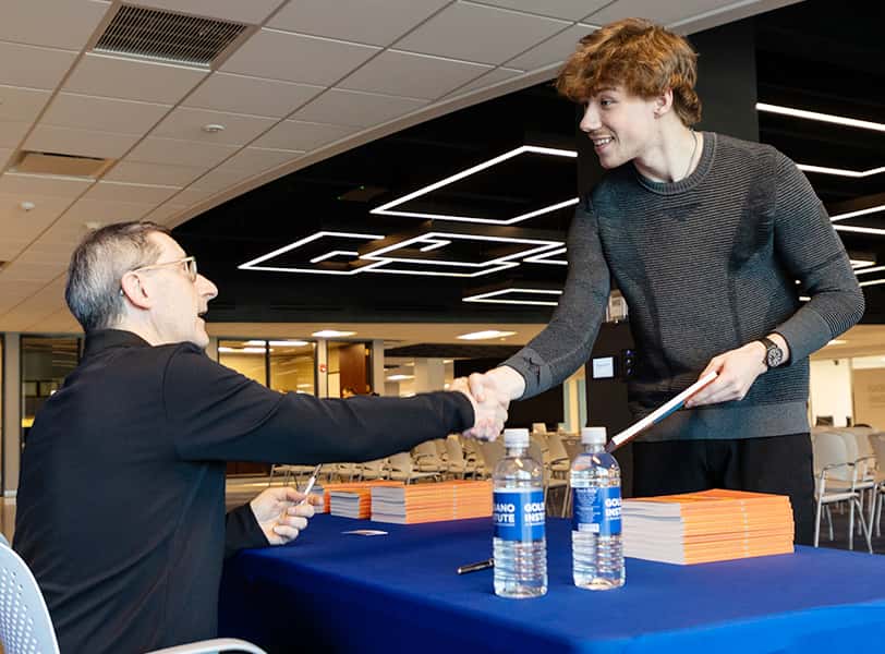 Student shaking hands with business partner.
