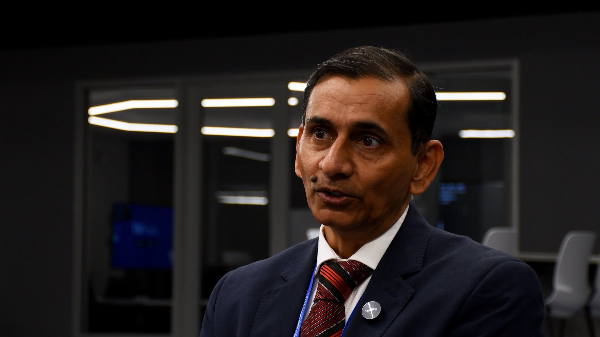 A man answers a question asked off camera about AI and business education.