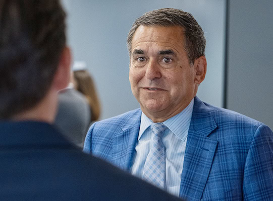 become-employer-partner Man in suit and tie speaking to student.