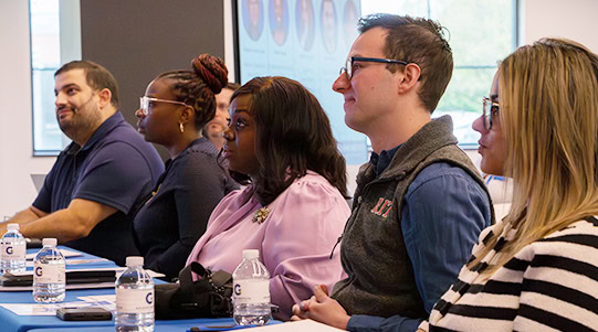 A group of judges listening to student pitches.