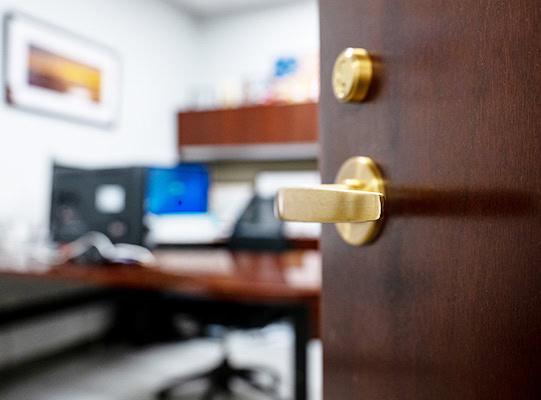 offices-suites Close up photo of an office door handle showing the door slightly open.