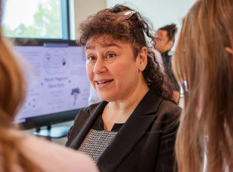 Woman speaking with a group of people.