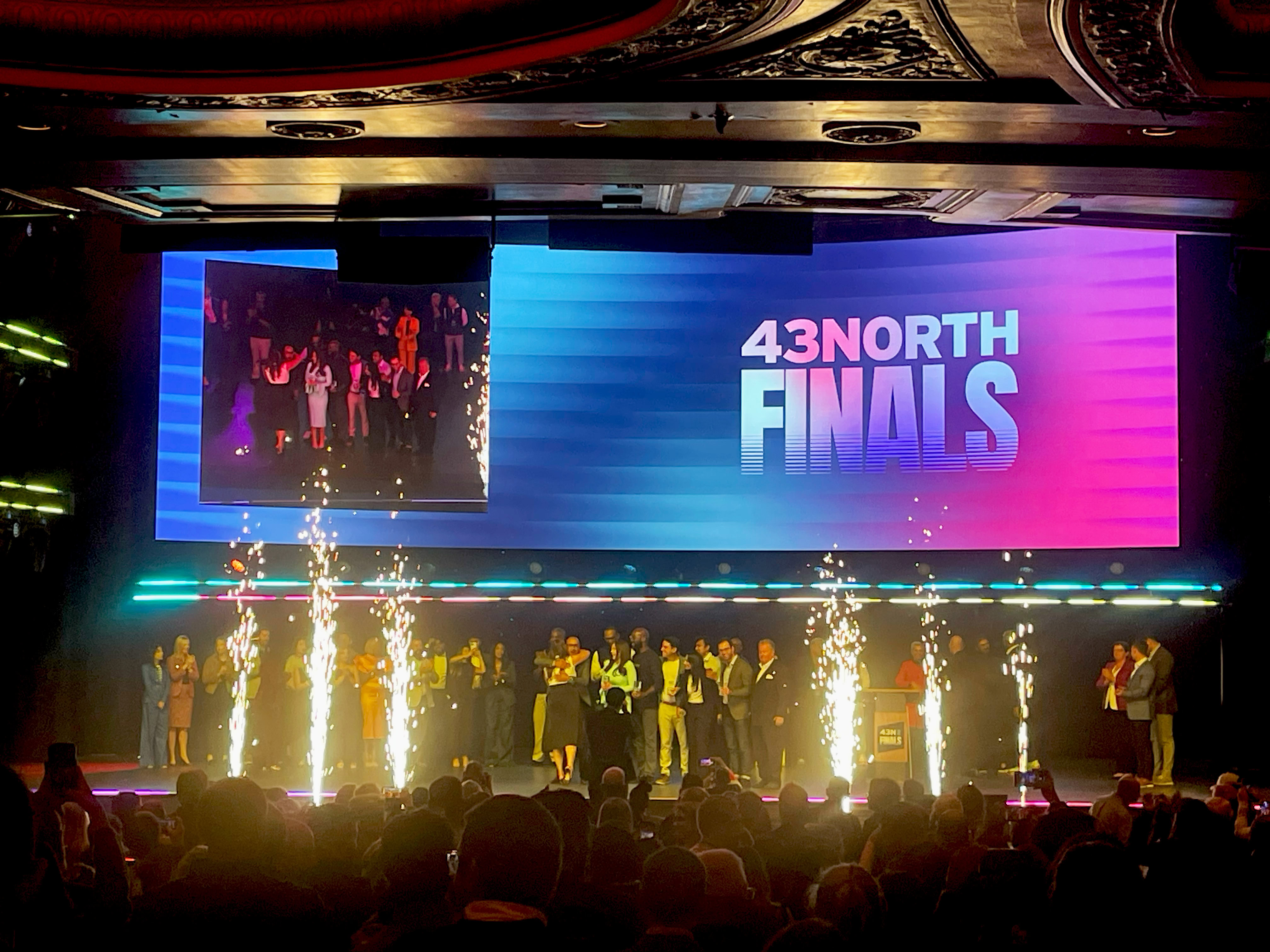 A theatre stage in Buffalo, NY, alight with fire works and a large digital screen that reads "43North Finals"