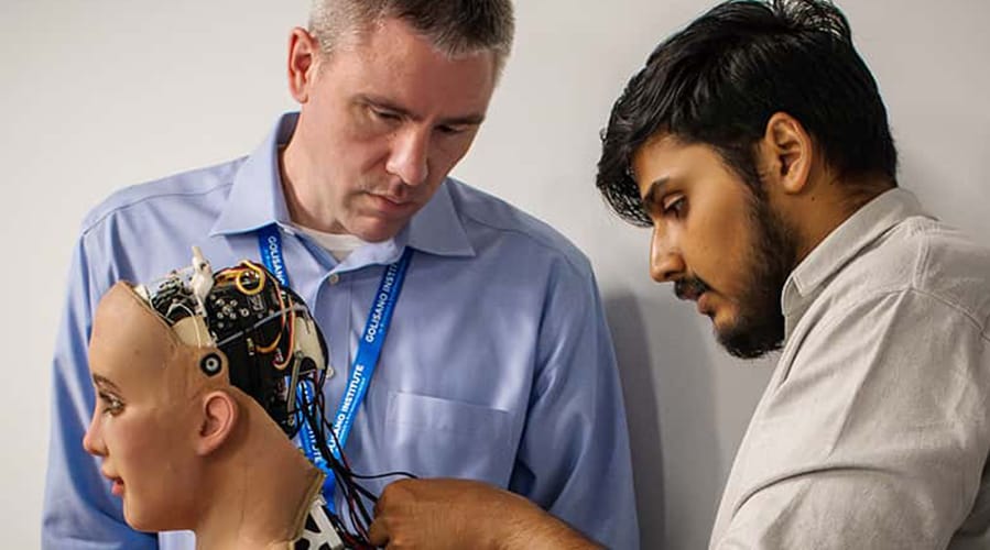 Two men working on an AI powered robot humanoid.