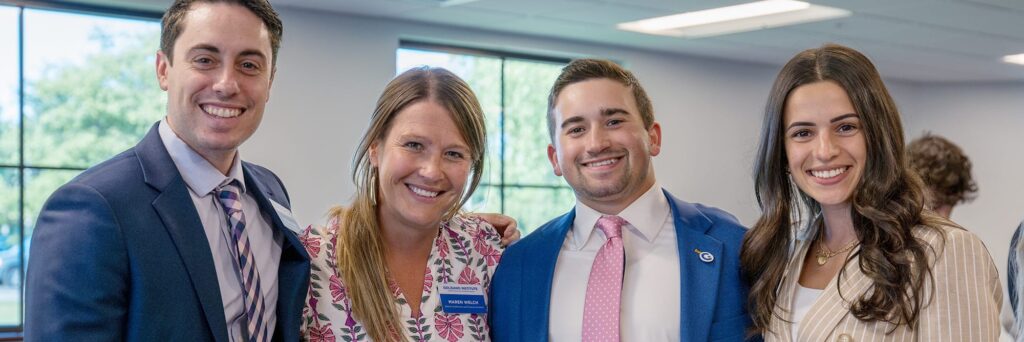 Four people smiling and posing for the camera.