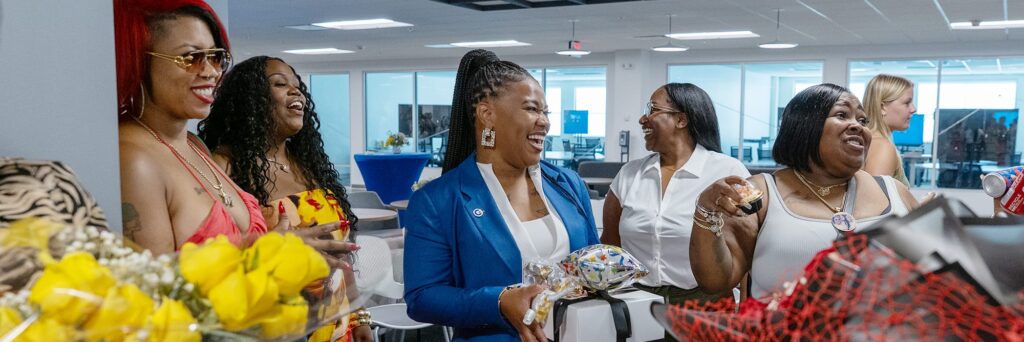 A group of people laughing and smiling at an event.