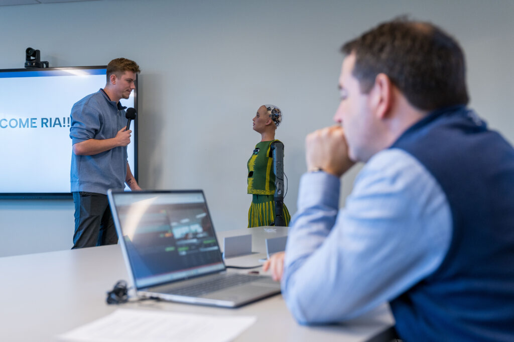 Golisano Institute faculty member manages an in-class AI simulation with a humanoid robot
