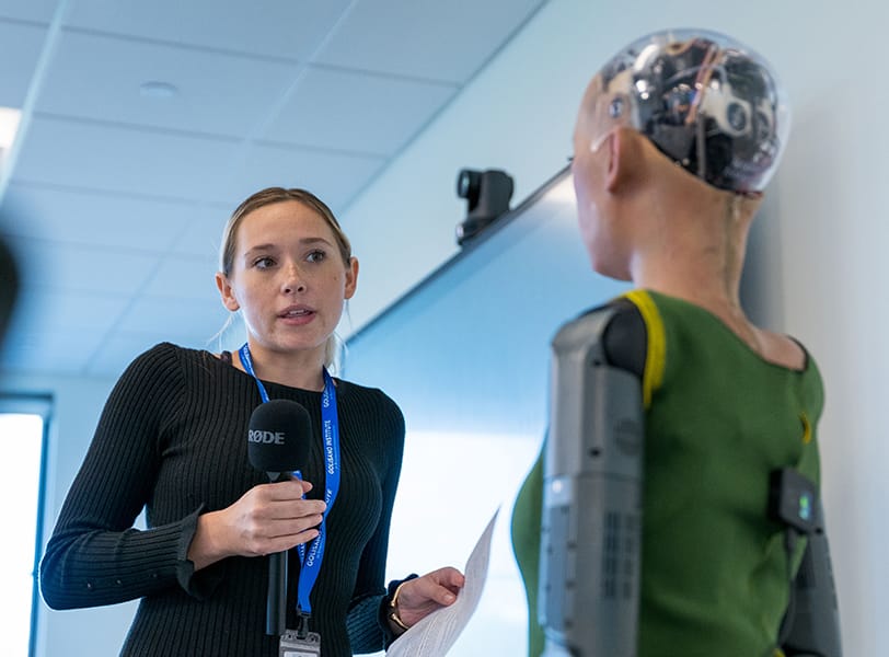 A woman engages with an AI powered humanoid robot.