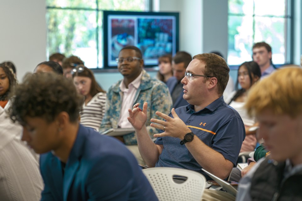A student ask a question in the middle of a classroom.