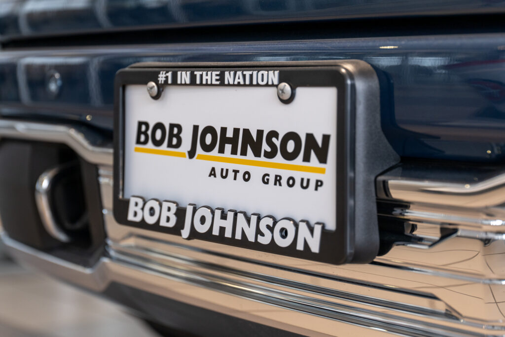 A license plate on a new car with the name of the dealership, Bob Johnson Auto Group