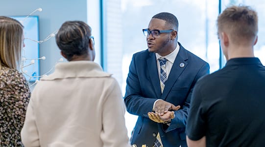 A Golisano Institute student explains his business idea to a group of business partners.
