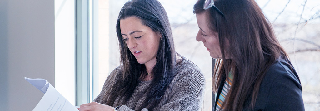 A student and an instructor review a document together.