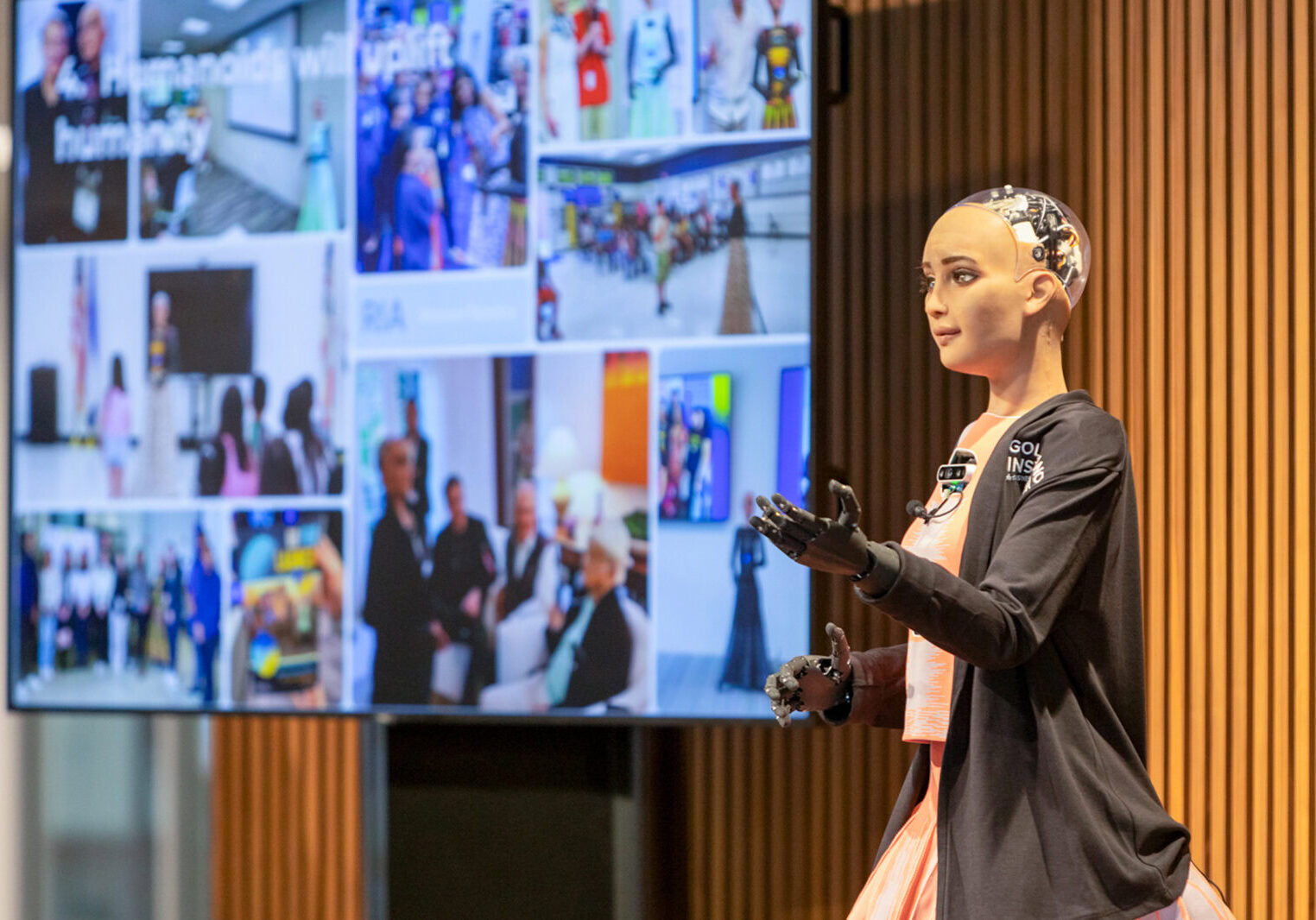 A humanoid robot called RIA, powered by AI, is pictured on a stage by a screen at Golisano Institute for Business & Entrepreneurship