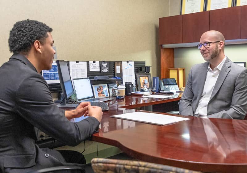 Student speaking with faculty member in his office